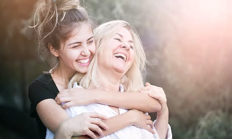 Umarmung einer glücklichen Mutter mit Kind