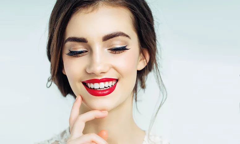 Attraktive Frau mit schönen, geraden Zähnen und roten Lippen