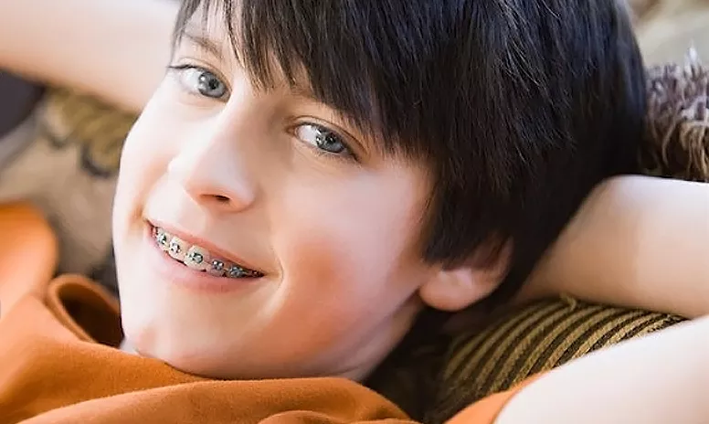 Lächelnder Junge mit fester Zahnspange
