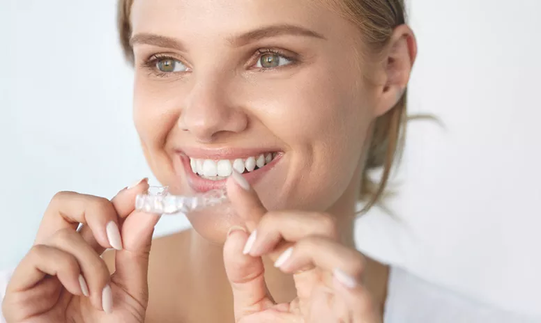 Lachender Teenager mit Invisalign Aligner