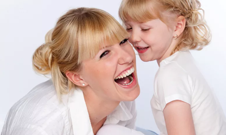 Lachende erwachsene Frau mit lingualer Zahnspange