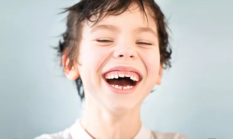 Lachender Junge mit schiefen Zähnen
