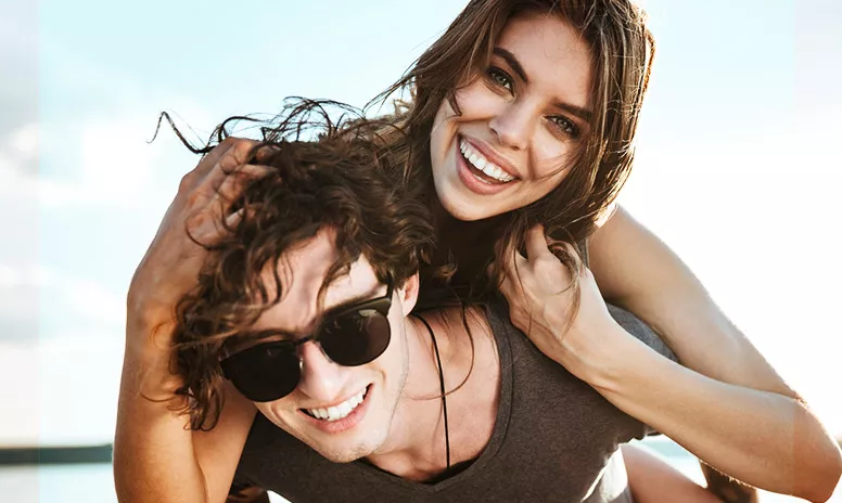 Glückliches Paar mit schönen, geraden Zähnen durch Aligner-Therapie
